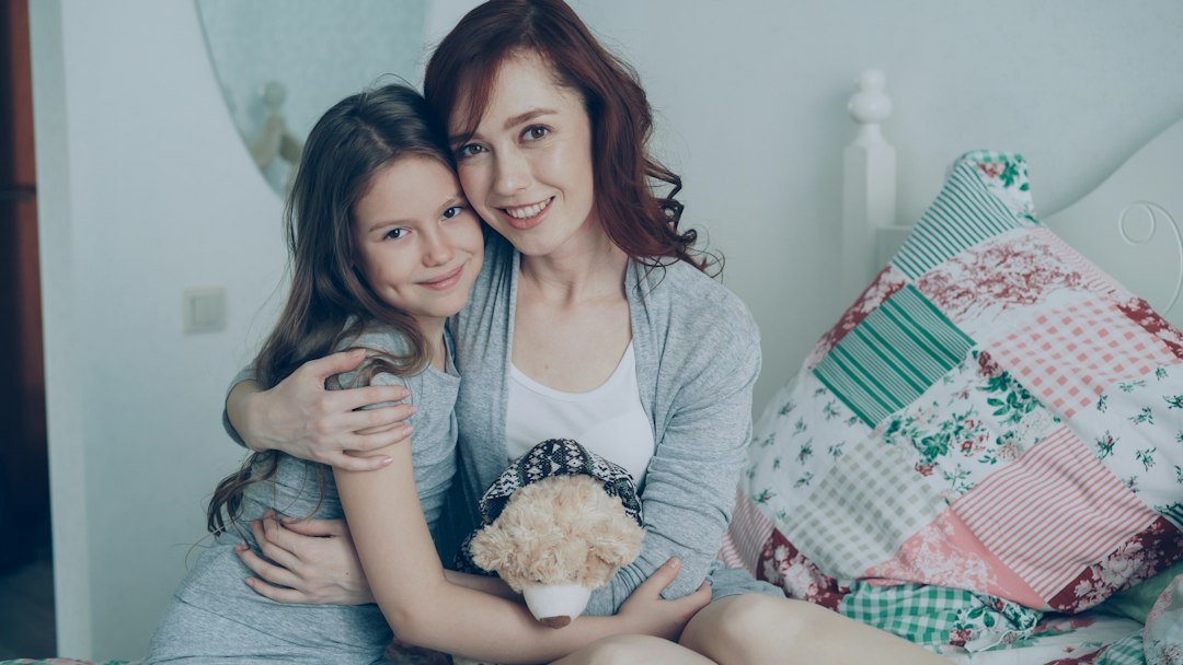 Mother and daughter smiling together at home
