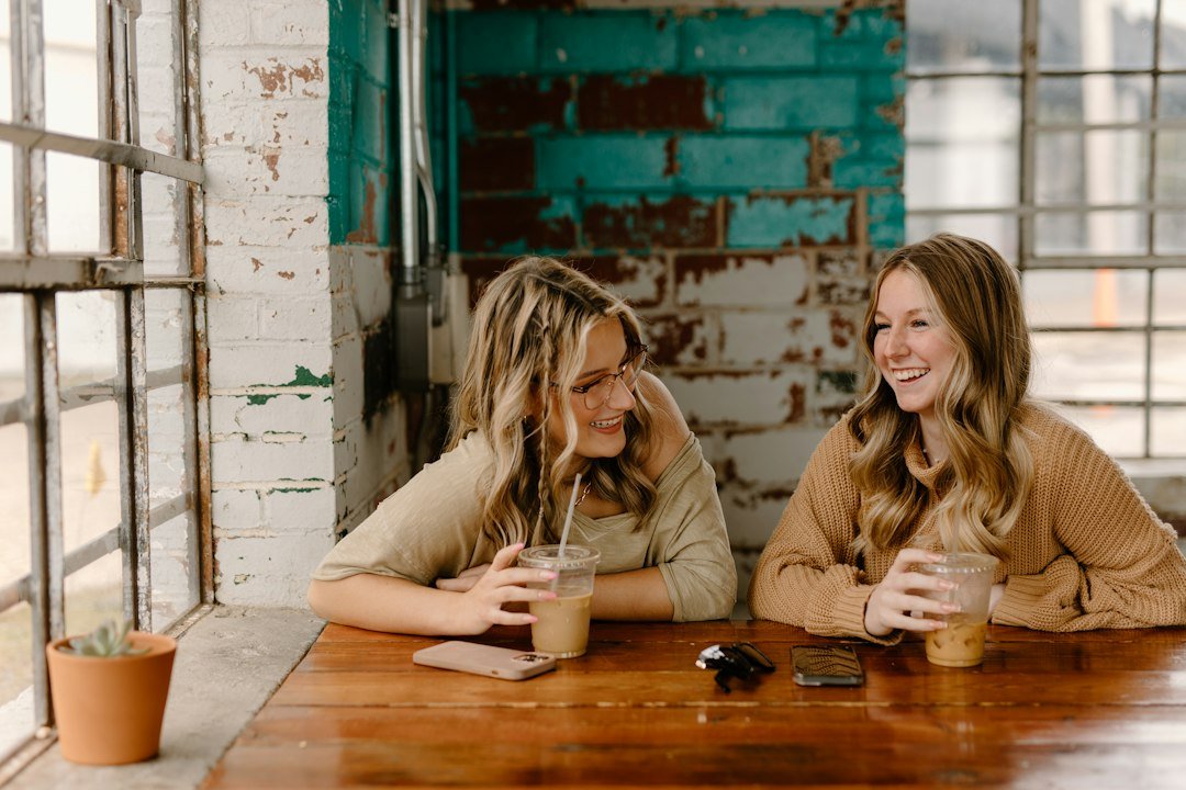 Two women friends laughing together over coffee